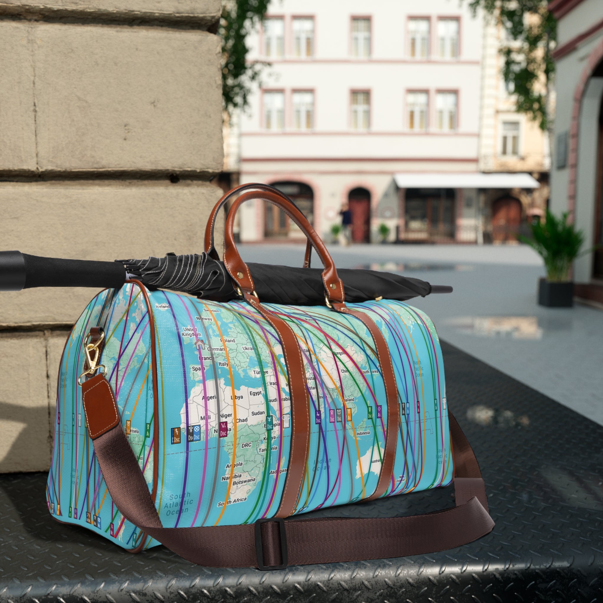 Colorful weekender travel bag with personalized astrocartography world map design on a table outdoors with an umbrella on top, for scale