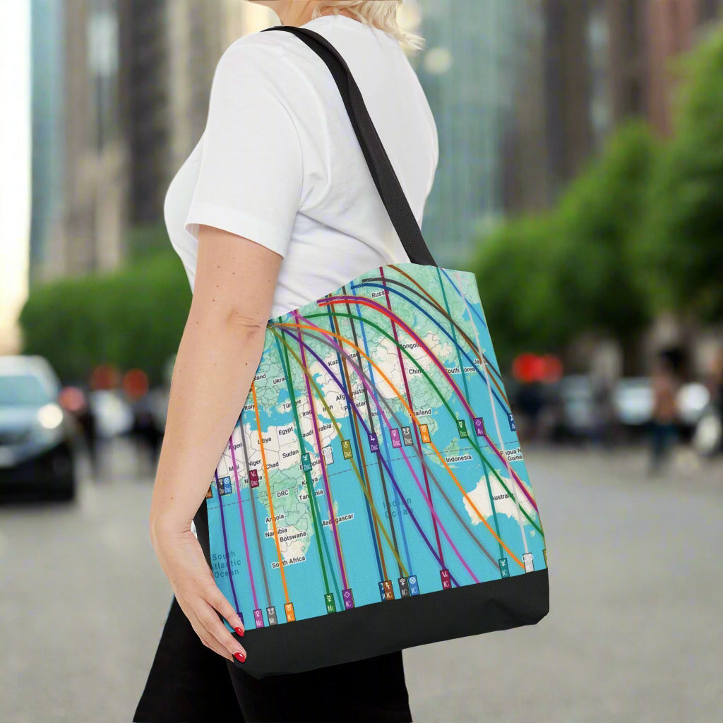woman holding a colorful tote bag with a colorful personalized astrocartography world map design walking in a city