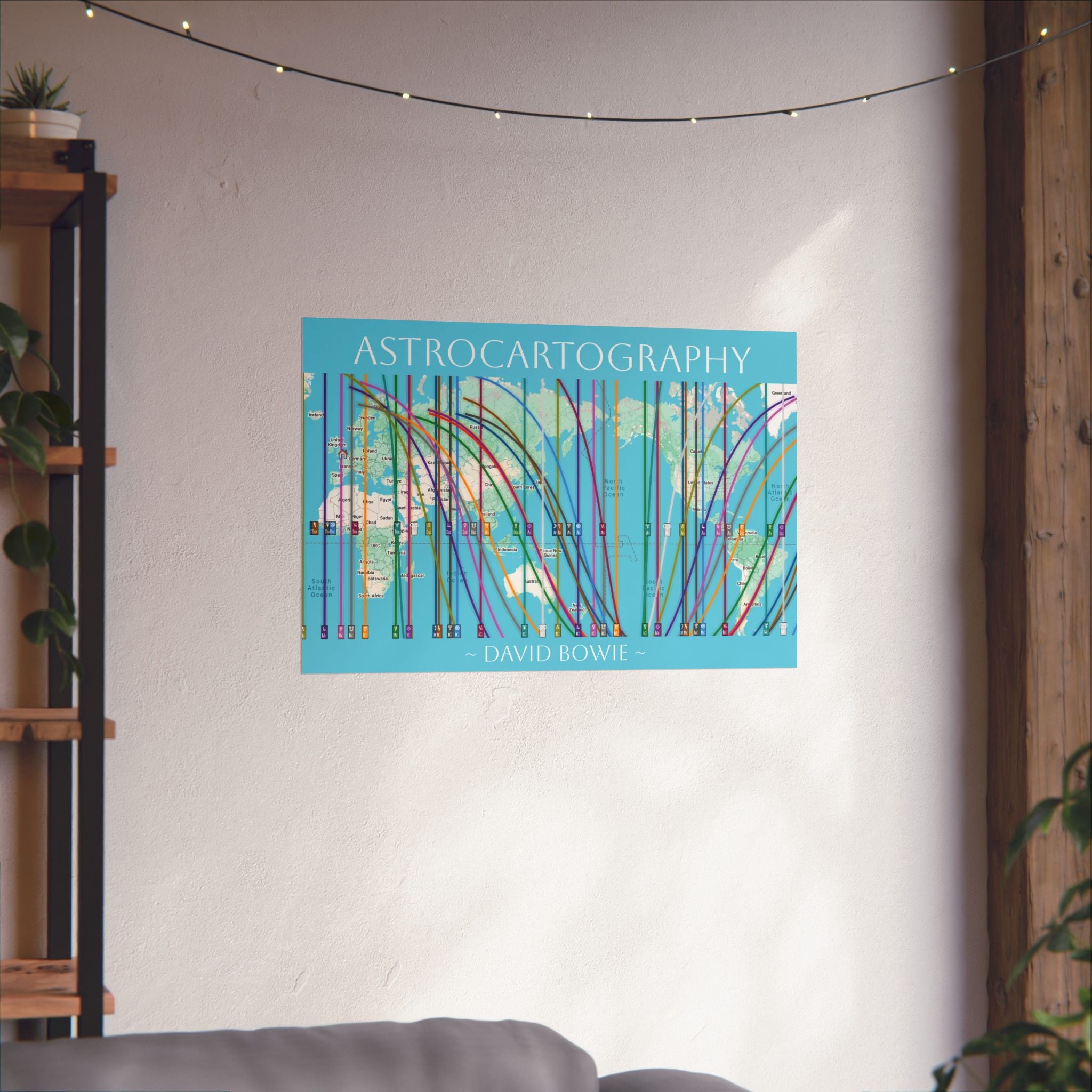 'Astrocartography' poster showing David Bowie's global astrology map on a wall in a room with a shelf and plants.