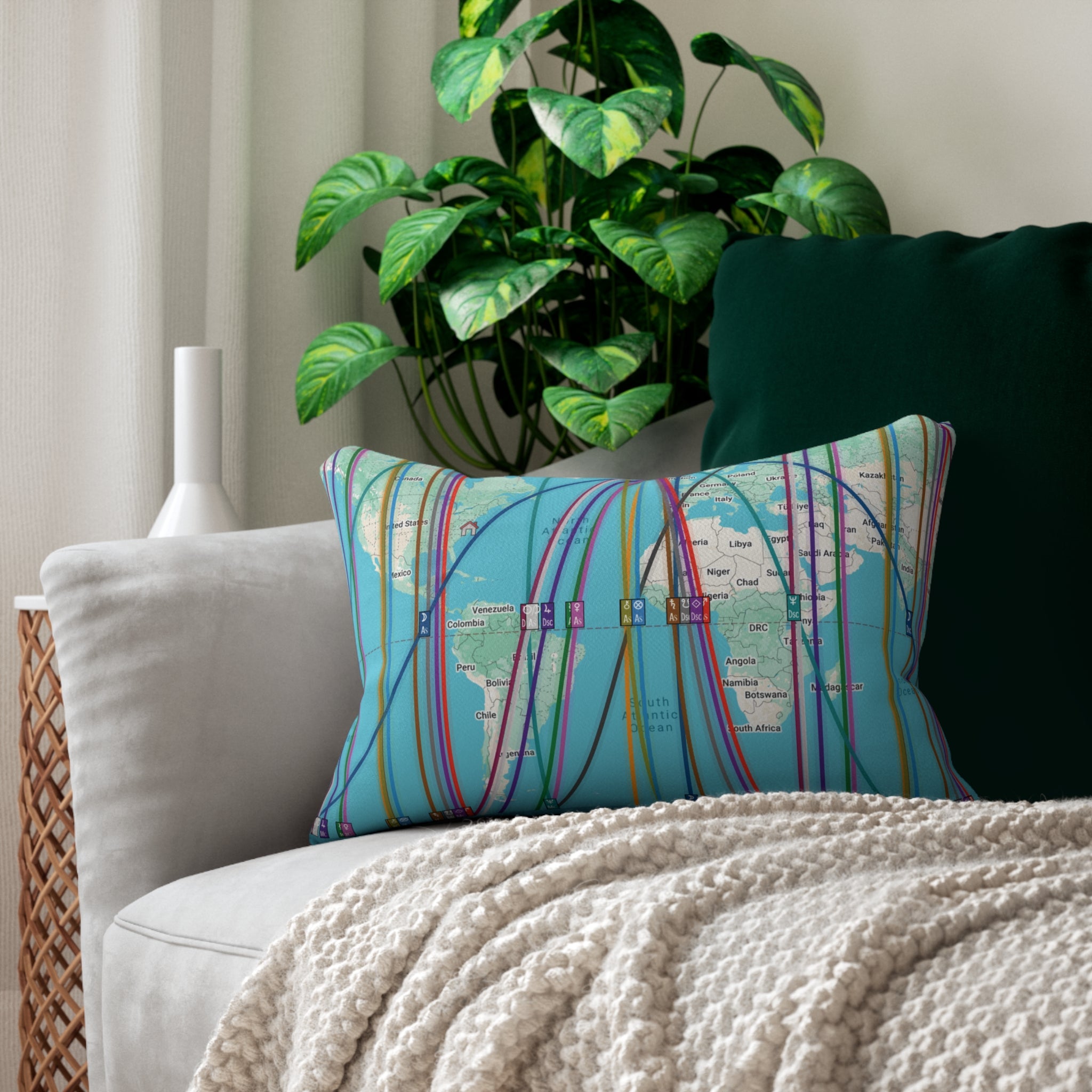 Decorative personalized astrocartography map throw pillow on a couch with a plant in the background