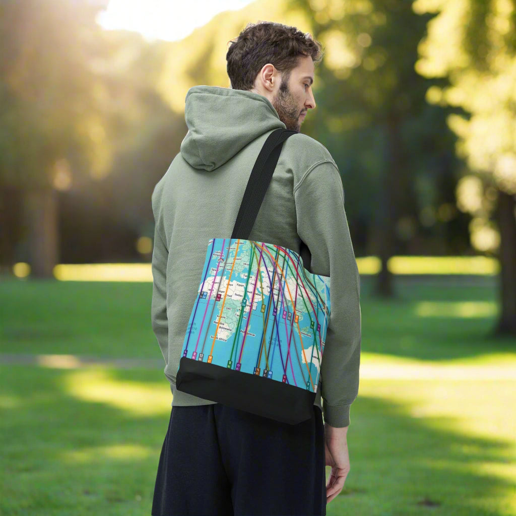 Man wearing a green hoodie with a colorful personalized astrocartography world map bag over his shoulder in a park
