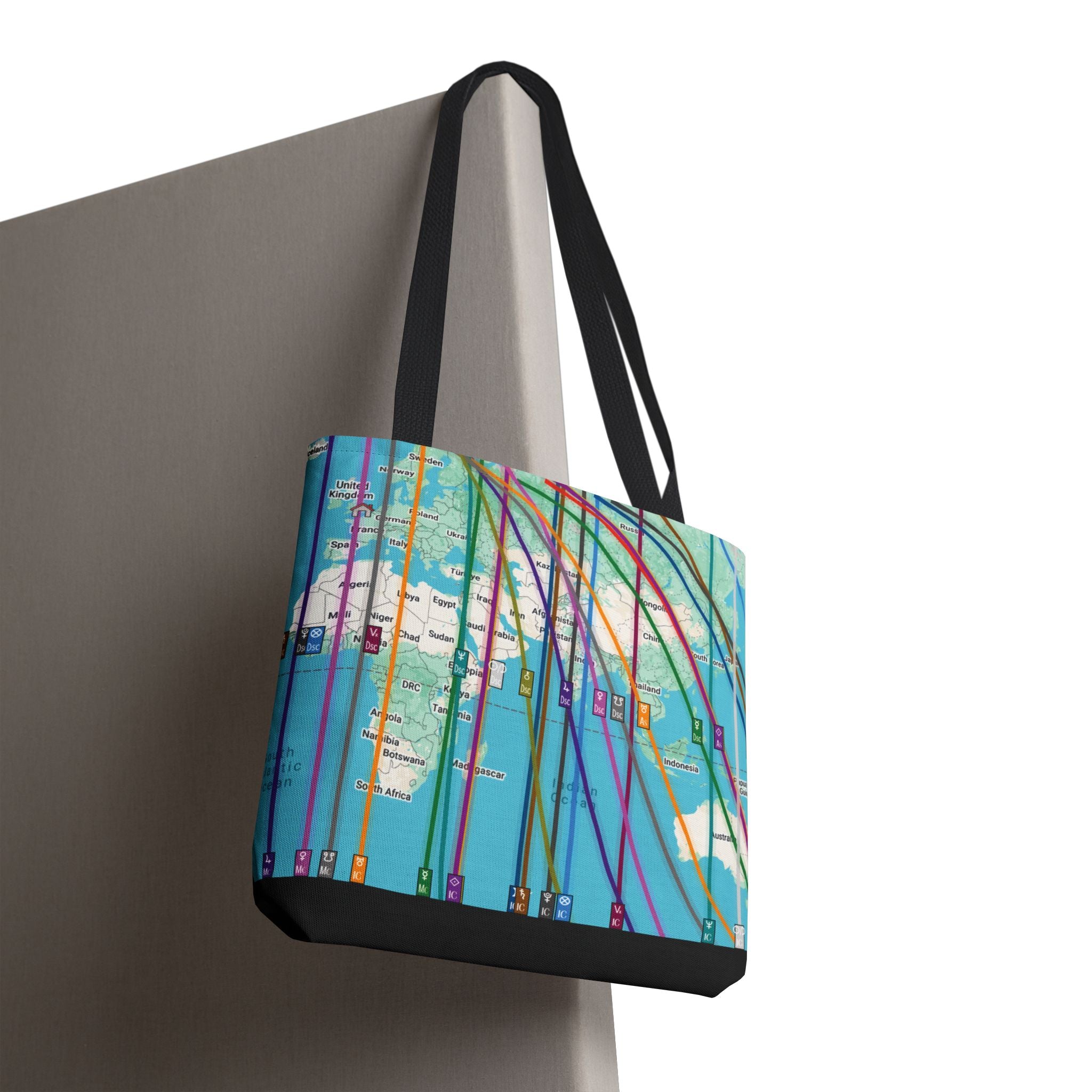 Tote bag with colorful personalized astrocartography world map design hanging on a chair